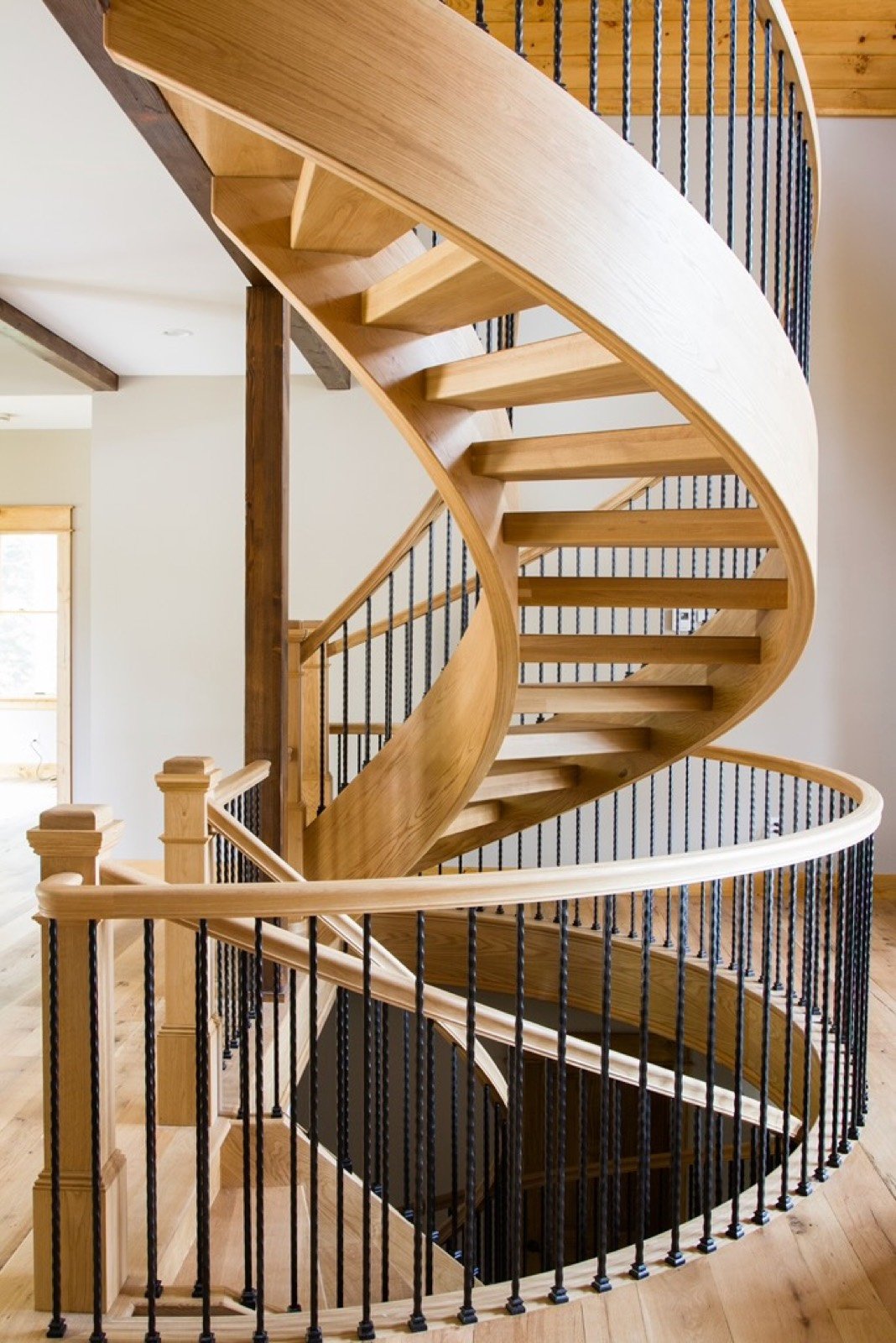 Sweeping curved staircase with iron balusters