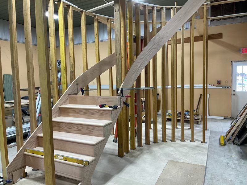 Curved staircase and sweeping wooden handrail being fabricated in the Capital District Stairs workshop