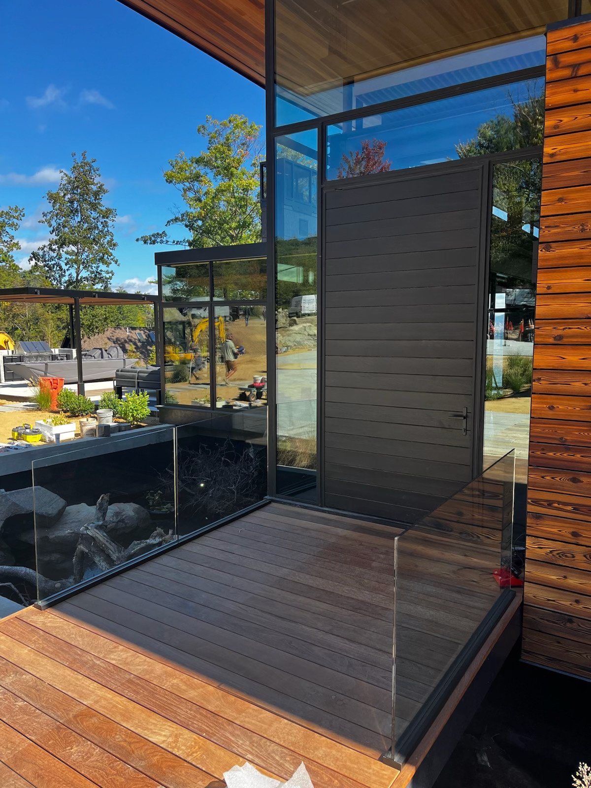 Minimal glass railing enclosing a warm wood stair opening