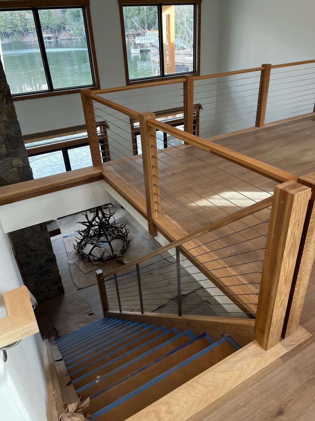 Custom wood landing railing overlooking a modern open stairwell